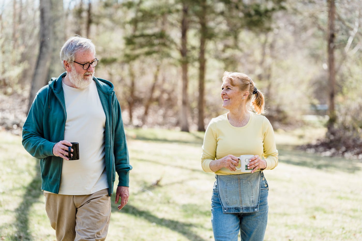A bright, uplifting photo of an older adult walking confidently outdoors in the sunshine.